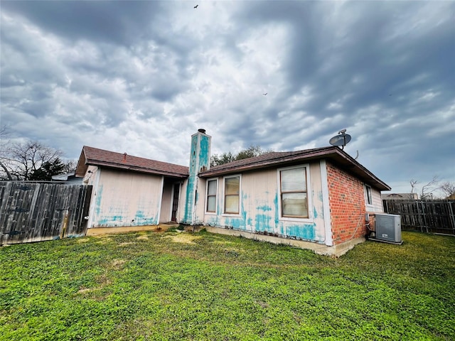 view of front of home featuring a front lawn and cooling unit