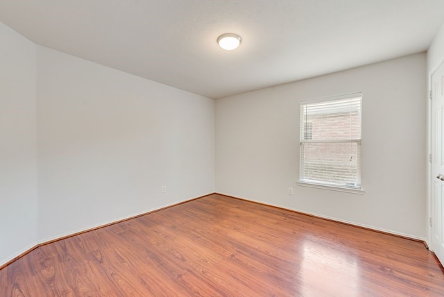 unfurnished room with wood-type flooring