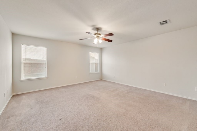 carpeted spare room featuring ceiling fan