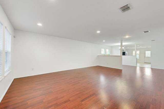 spare room featuring an inviting chandelier and hardwood / wood-style floors