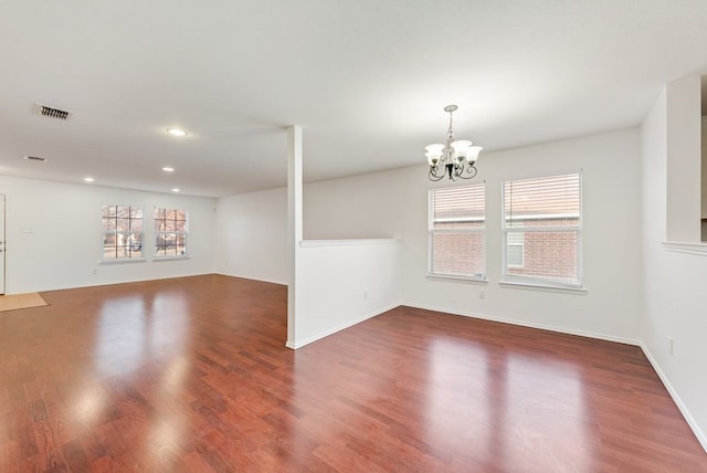 unfurnished room featuring dark hardwood / wood-style floors and a notable chandelier