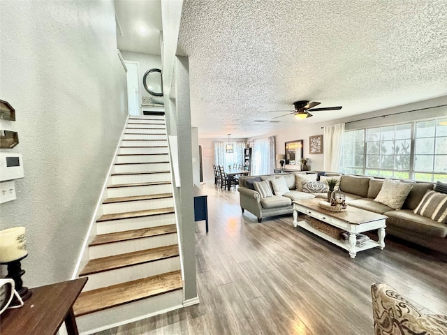 living room featuring a textured ceiling, ceiling fan, a wealth of natural light, and hardwood / wood-style floors