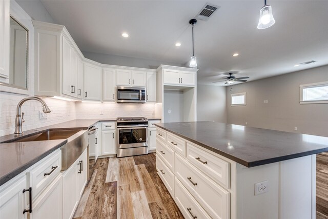 kitchen featuring white cabinetry, wood-type flooring, hanging light fixtures, and a center island