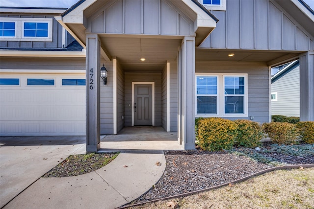 view of exterior entry featuring board and batten siding and a garage