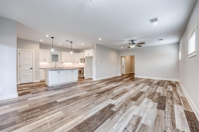 kitchen featuring stainless steel appliances, pendant lighting, and white cabinetry