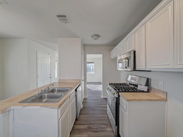 kitchen featuring sink, white cabinetry, appliances with stainless steel finishes, and dark hardwood / wood-style flooring