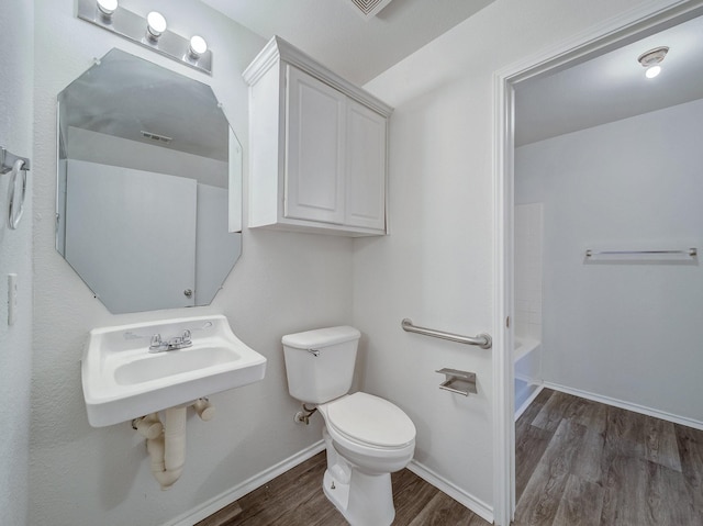 full bathroom featuring toilet, tub / shower combination, wood-type flooring, and sink