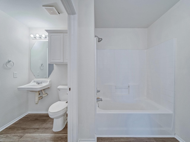 full bathroom featuring shower / bathing tub combination, wood-type flooring, toilet, and sink