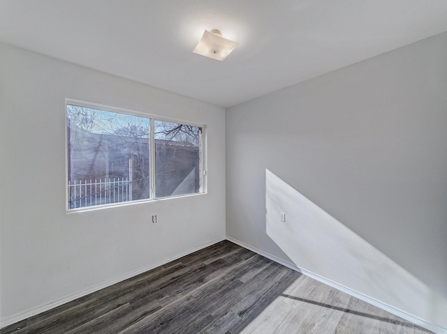 unfurnished room with dark hardwood / wood-style flooring