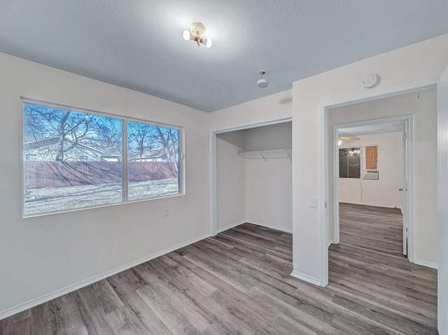 unfurnished bedroom featuring wood-type flooring, a closet, and a textured ceiling