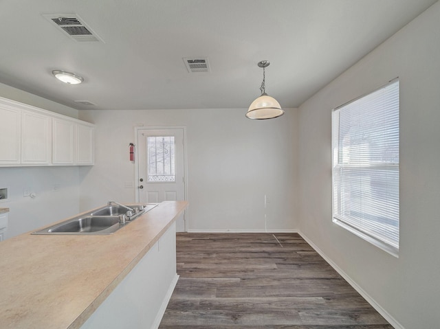 kitchen with white cabinets, sink, a healthy amount of sunlight, and pendant lighting