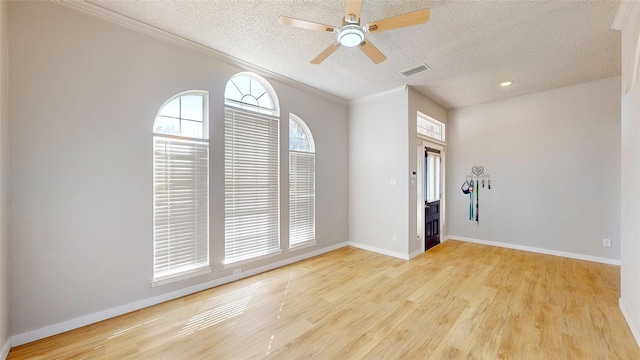 interior space featuring a textured ceiling, ceiling fan, crown molding, and light wood-type flooring