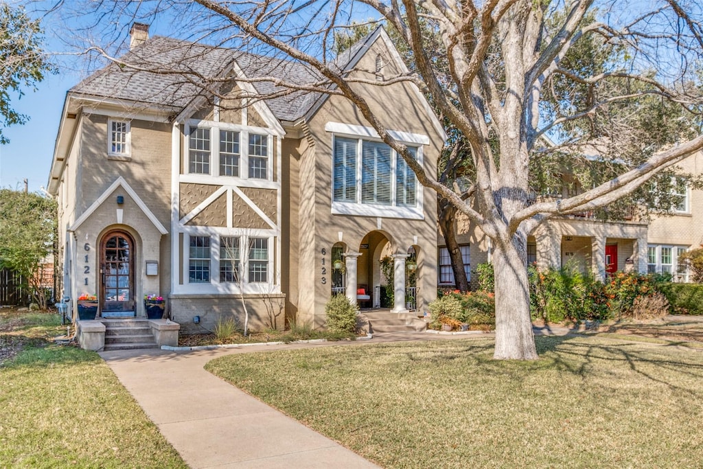 english style home featuring a front yard