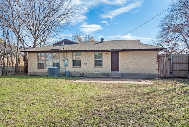 rear view of house with central air condition unit, a patio area, and a lawn