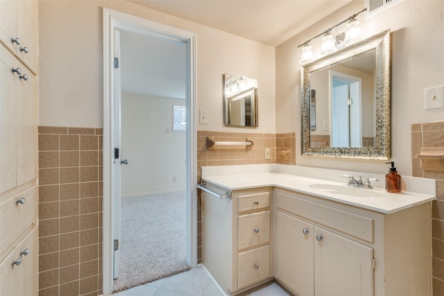 bathroom with tile walls, vanity, and tile patterned flooring