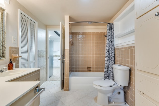 full bathroom featuring toilet, vanity, tile patterned flooring, tile walls, and shower / tub combo