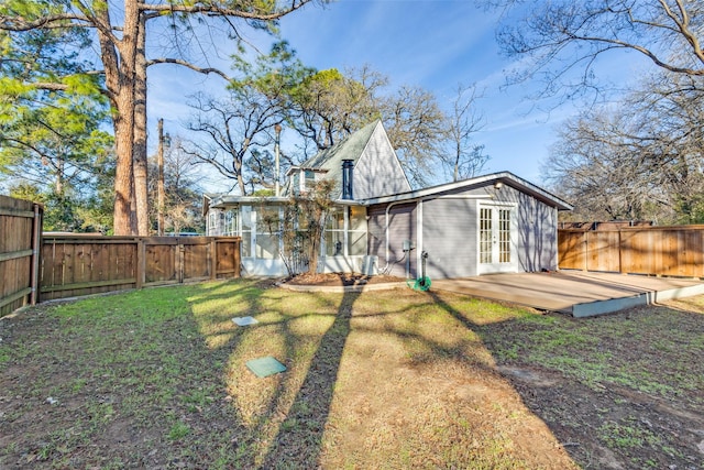 back of house featuring a yard, a wooden deck, and a sunroom