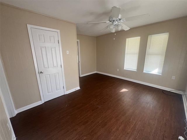 empty room featuring ceiling fan, dark hardwood / wood-style flooring, and ornamental molding