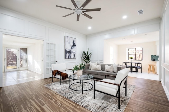 living room featuring ceiling fan, a wealth of natural light, and wood-type flooring