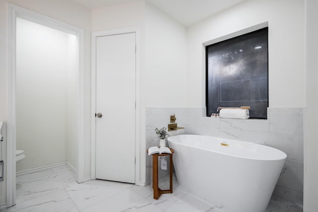 bathroom featuring tile walls and a tub