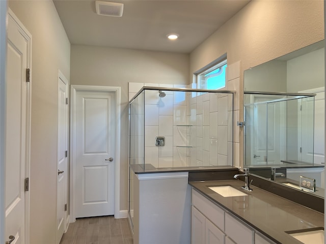 bathroom featuring vanity, wood-type flooring, and an enclosed shower