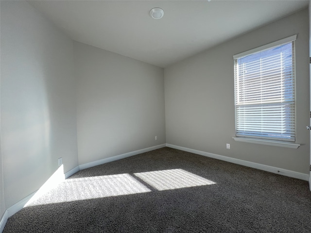 unfurnished room with dark carpet