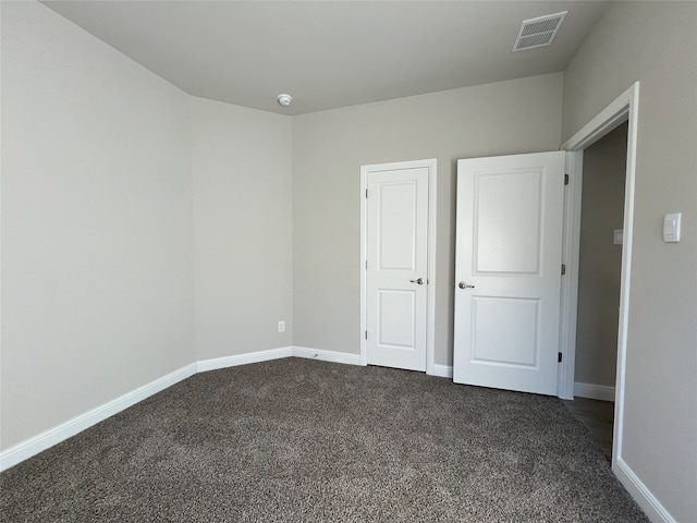 unfurnished bedroom with dark carpet