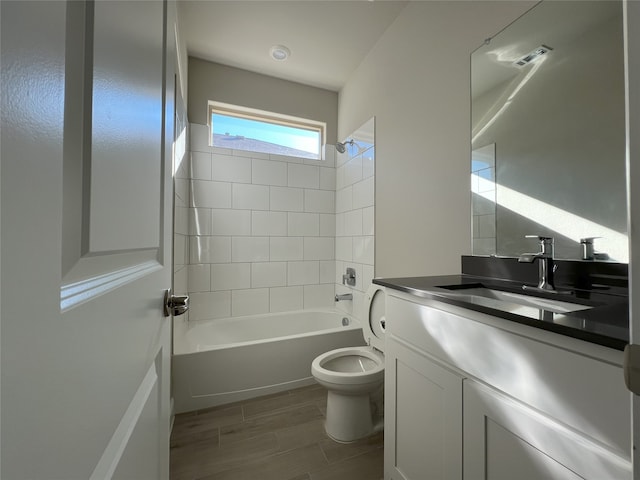 full bathroom featuring toilet, vanity, and tiled shower / bath