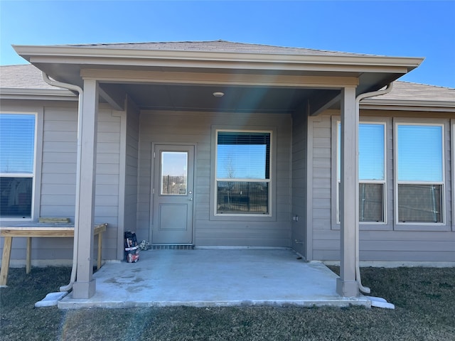 view of exterior entry with a patio