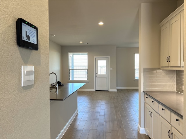 kitchen with decorative backsplash and white cabinetry