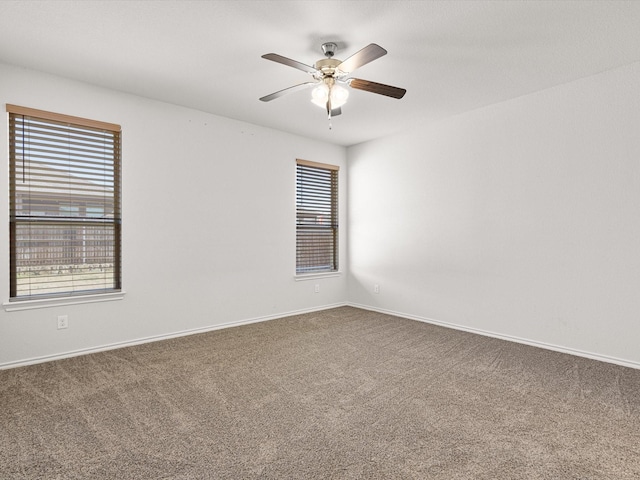 unfurnished room with carpet, baseboards, and a ceiling fan