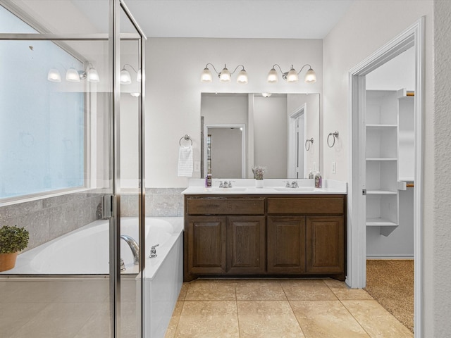 bathroom with a garden tub, a sink, a shower stall, tile patterned floors, and double vanity