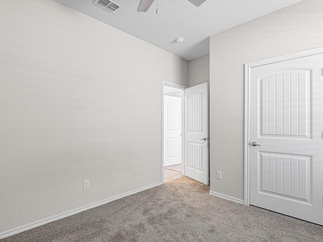 unfurnished bedroom with light colored carpet, visible vents, ceiling fan, and baseboards