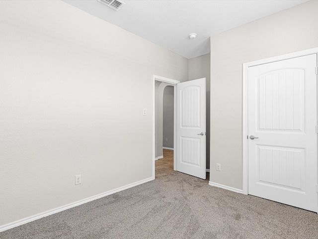 unfurnished bedroom featuring baseboards, visible vents, and light colored carpet