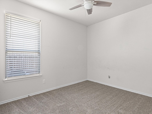 spare room with a ceiling fan, carpet flooring, and baseboards