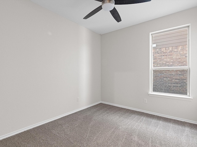 carpeted empty room with ceiling fan and baseboards