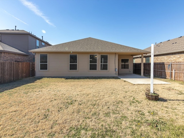 back of property with a patio area, a fenced backyard, and a yard