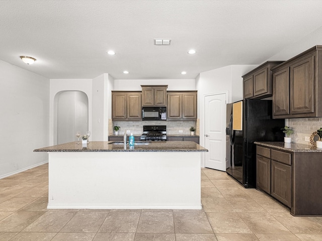 kitchen featuring a center island with sink, visible vents, black appliances, backsplash, and recessed lighting