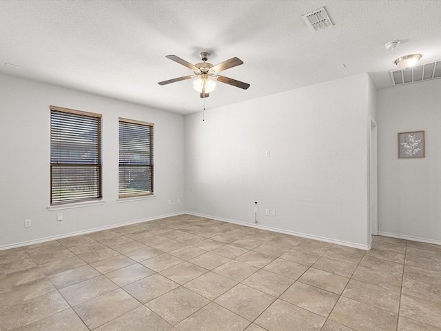 empty room featuring baseboards, a textured ceiling, visible vents, and a ceiling fan