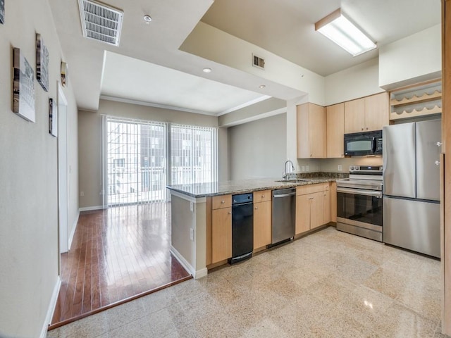 kitchen with kitchen peninsula, appliances with stainless steel finishes, sink, and light brown cabinets