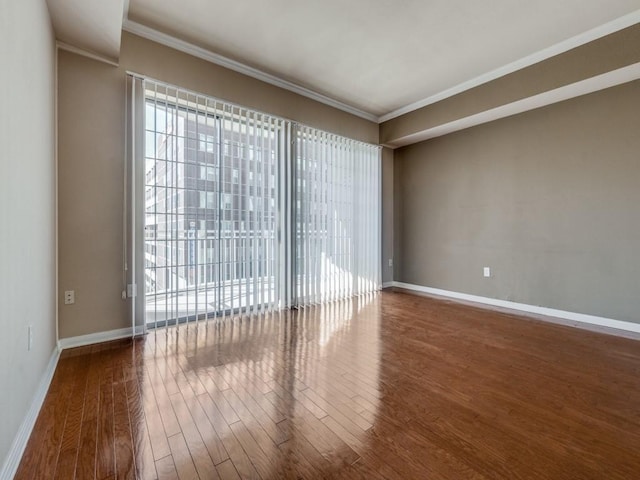 empty room featuring crown molding and hardwood / wood-style flooring