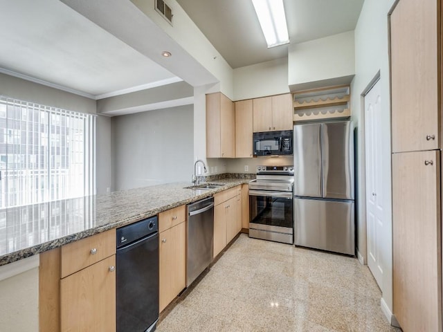 kitchen with light brown cabinets, stainless steel appliances, kitchen peninsula, and light stone counters