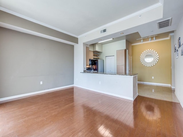 unfurnished living room with light hardwood / wood-style floors, sink, ornamental molding, and track lighting