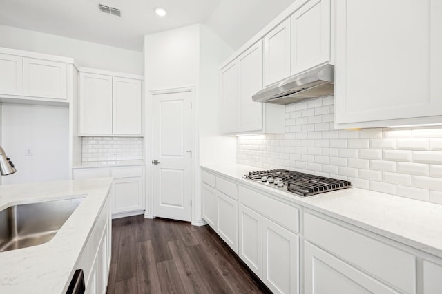 kitchen featuring dark hardwood / wood-style floors, sink, white cabinets, stainless steel gas cooktop, and light stone countertops