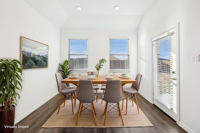 dining space with vaulted ceiling and dark wood-type flooring