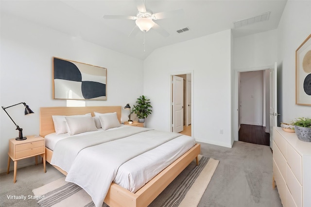 carpeted bedroom with ceiling fan and vaulted ceiling