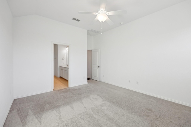 unfurnished bedroom with ensuite bathroom, lofted ceiling, light carpet, and ceiling fan