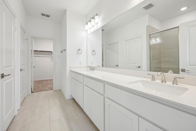 bathroom featuring a shower with door, vanity, and tile patterned flooring