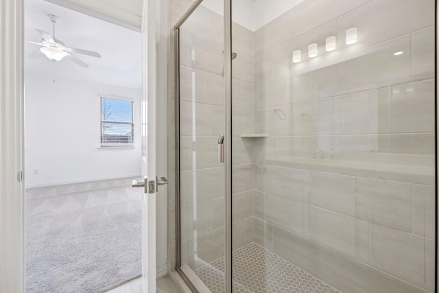 bathroom featuring a shower with shower door and ceiling fan