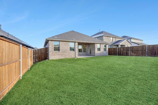 rear view of house with a patio and a yard